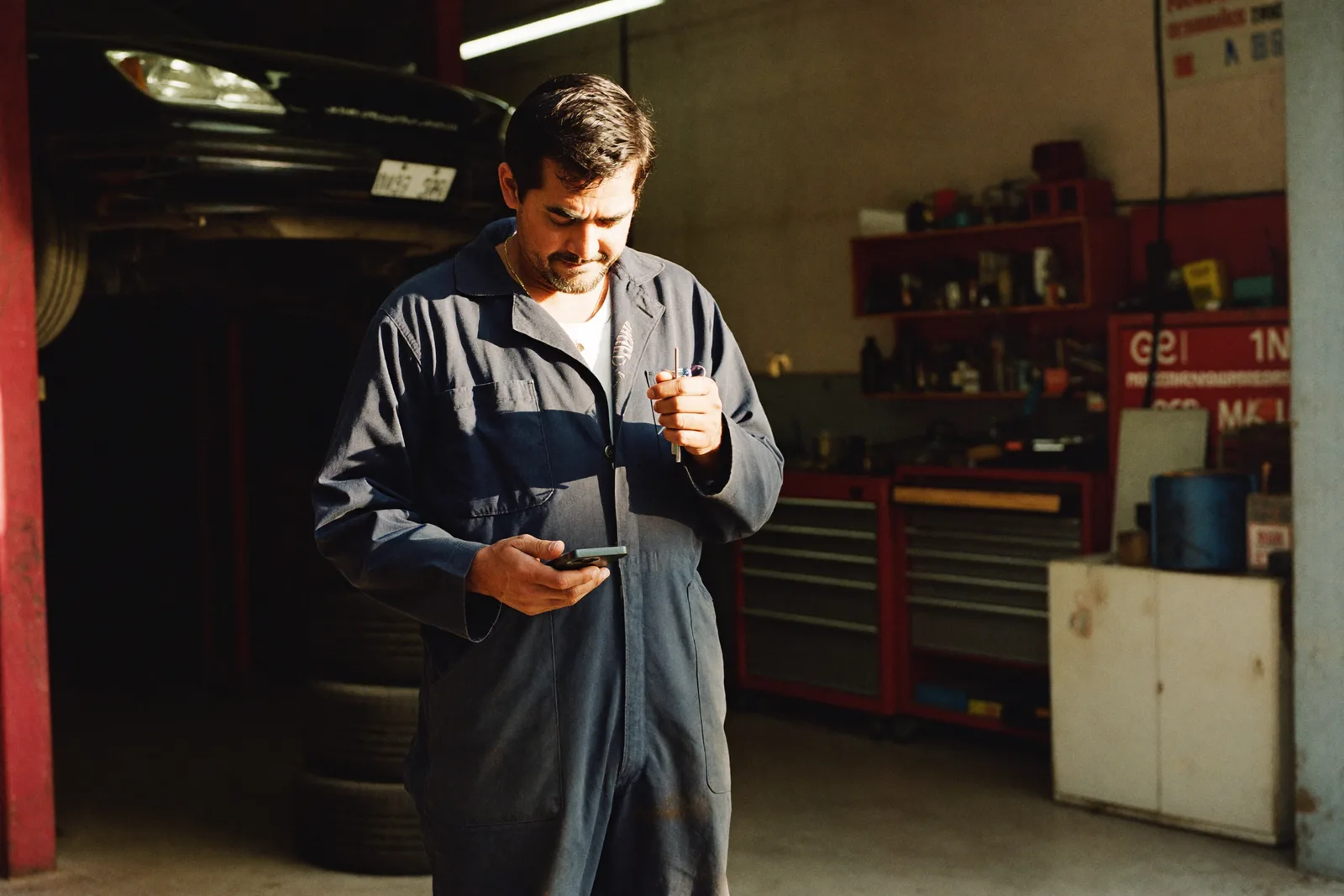 Mecânico usando o Torquecix no celular dentro da oficina
